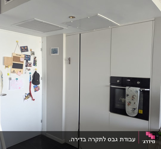 קיר גבס עם תנור בנוי ומגבת תלויה